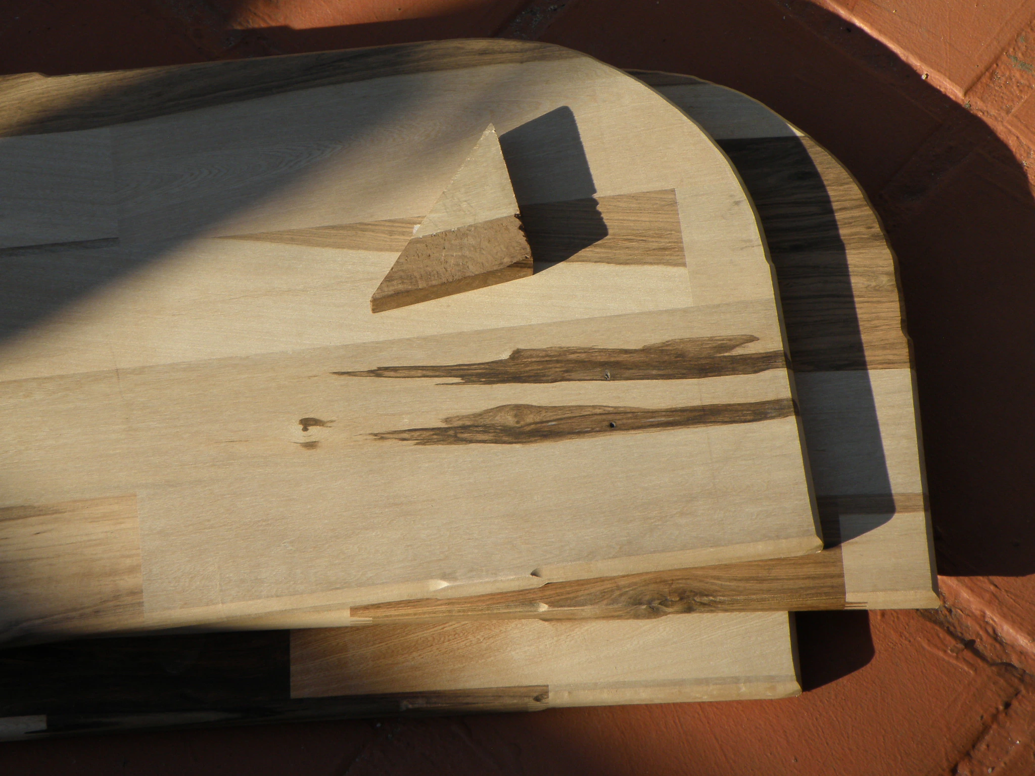 Tablas de madera apiladas con sombras de sol