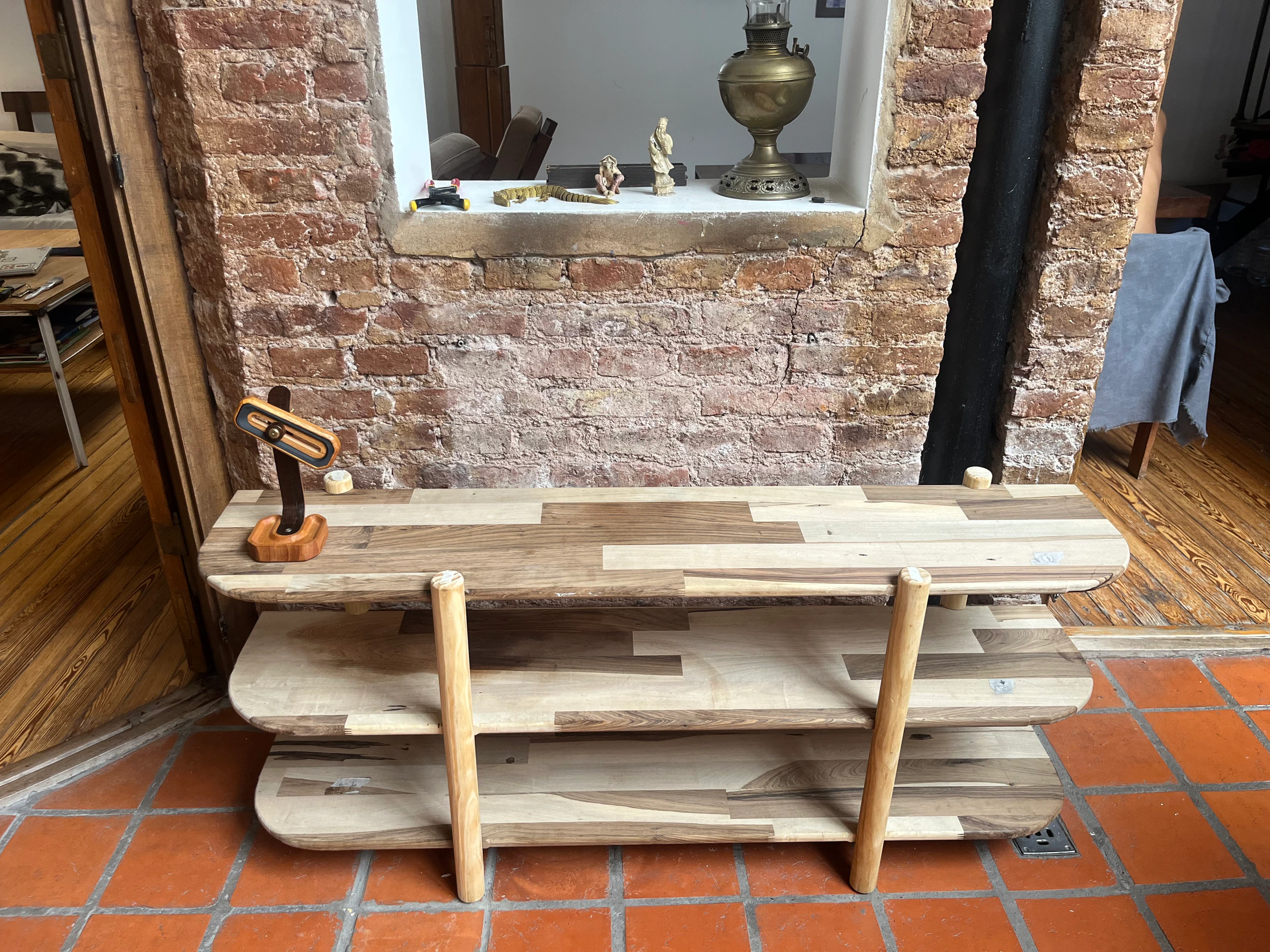 Estantería en interior con pared de ladrillo y lámpara