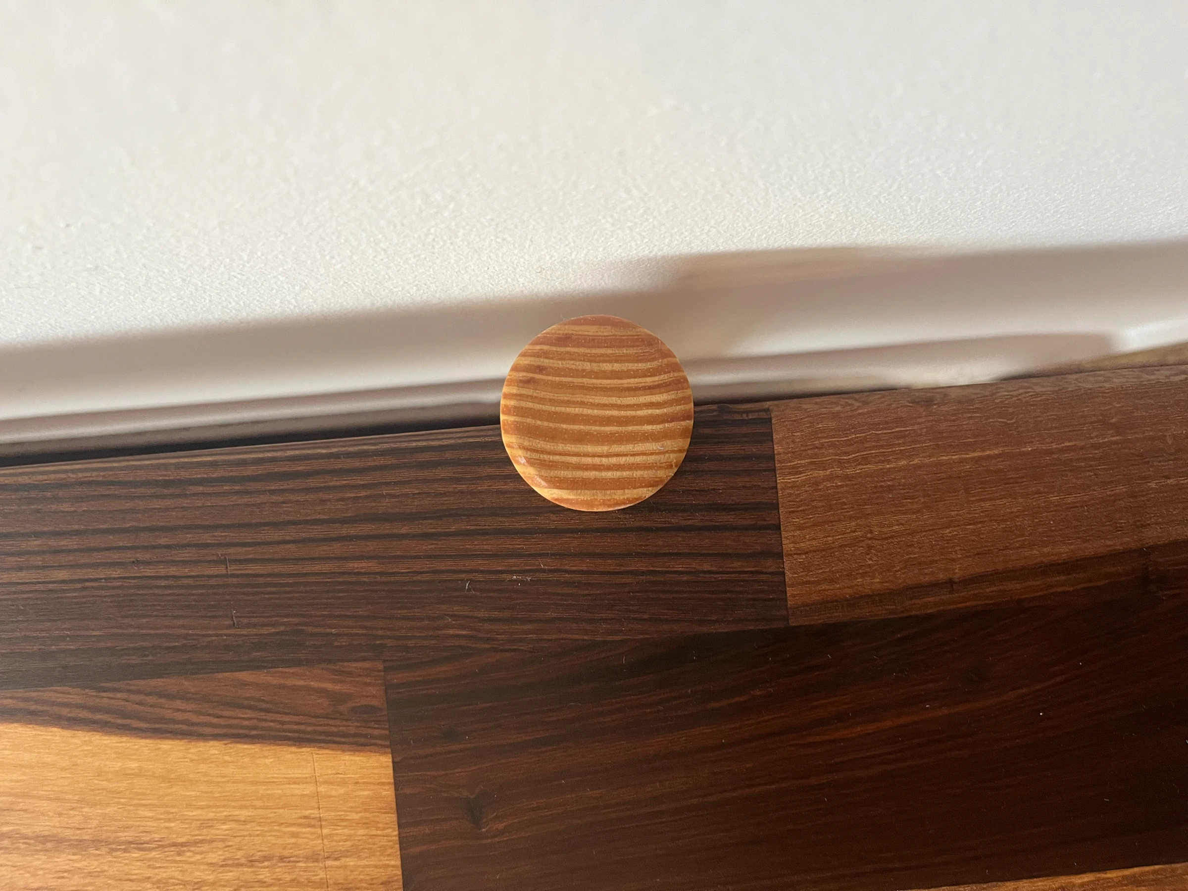 Tapa de tarugo sobre madera oscura terminada