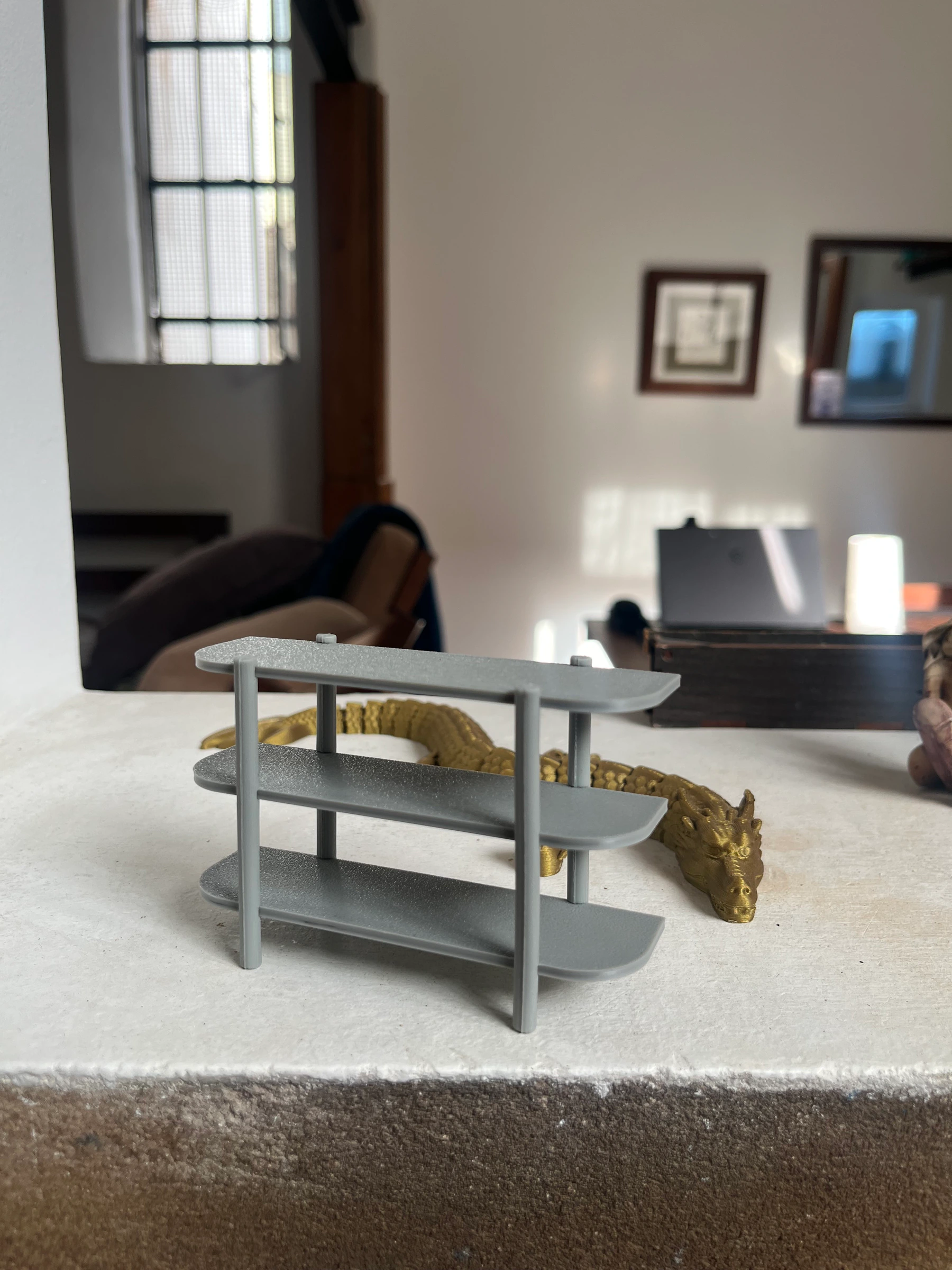 Maqueta a escala de la estantería con figura dorada