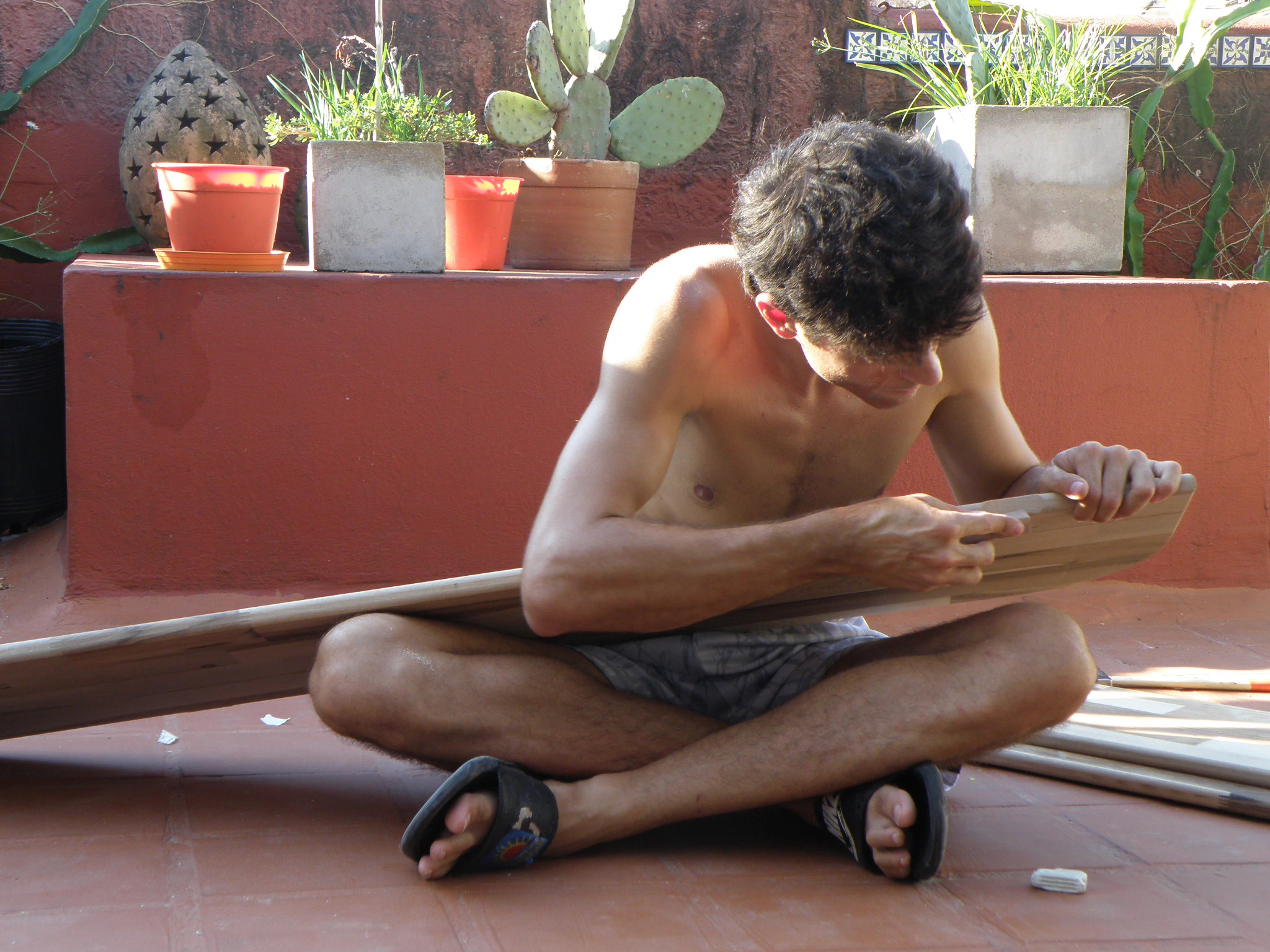 Lijando tabla de madera sentado en la terraza